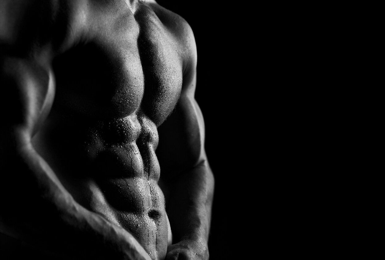 Close-up of muscular torso in black and white.