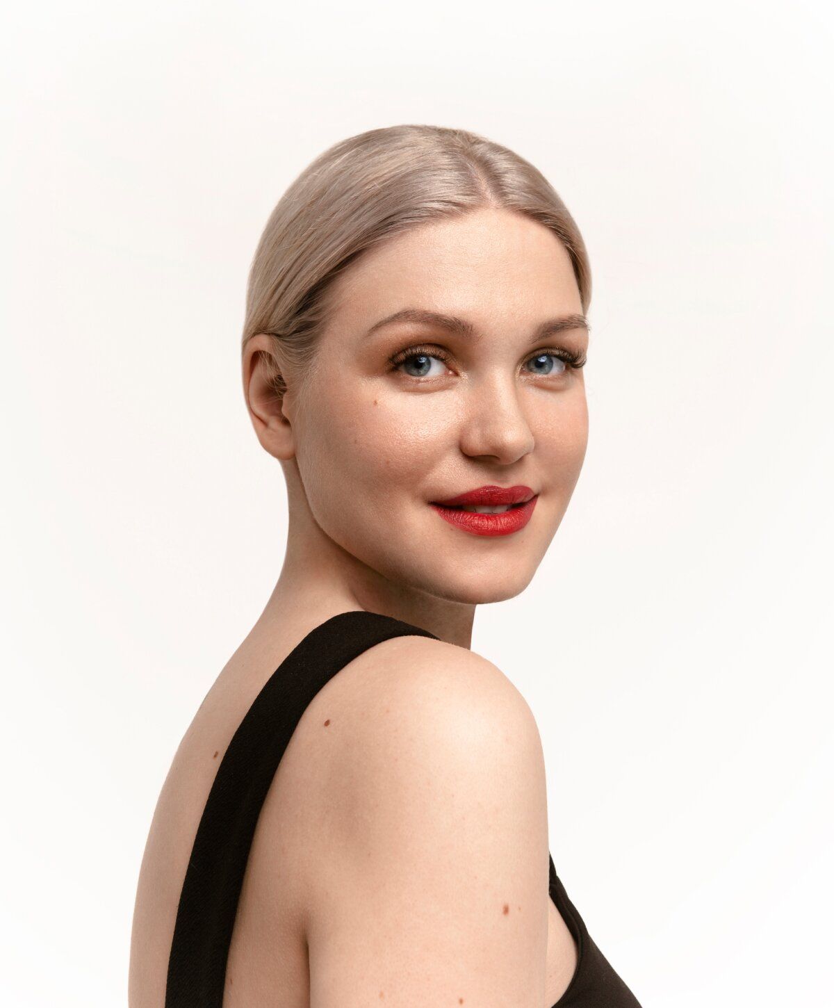 Smiling chin implant model with blonde hair and red lipstick.