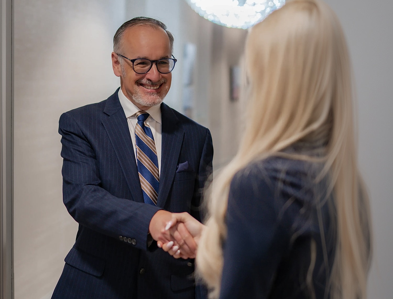 Business professionals shaking hands in an office.