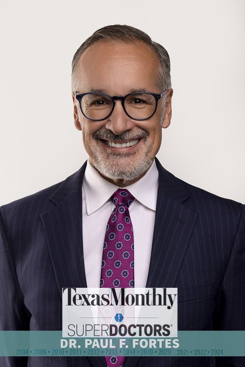 Smiling doctor in suit with glasses and tie.