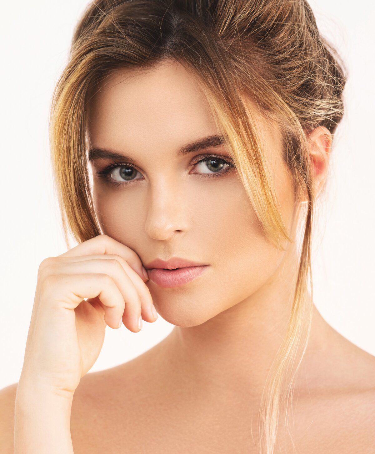 Close-up of a dermal filler model's face, softly posed.