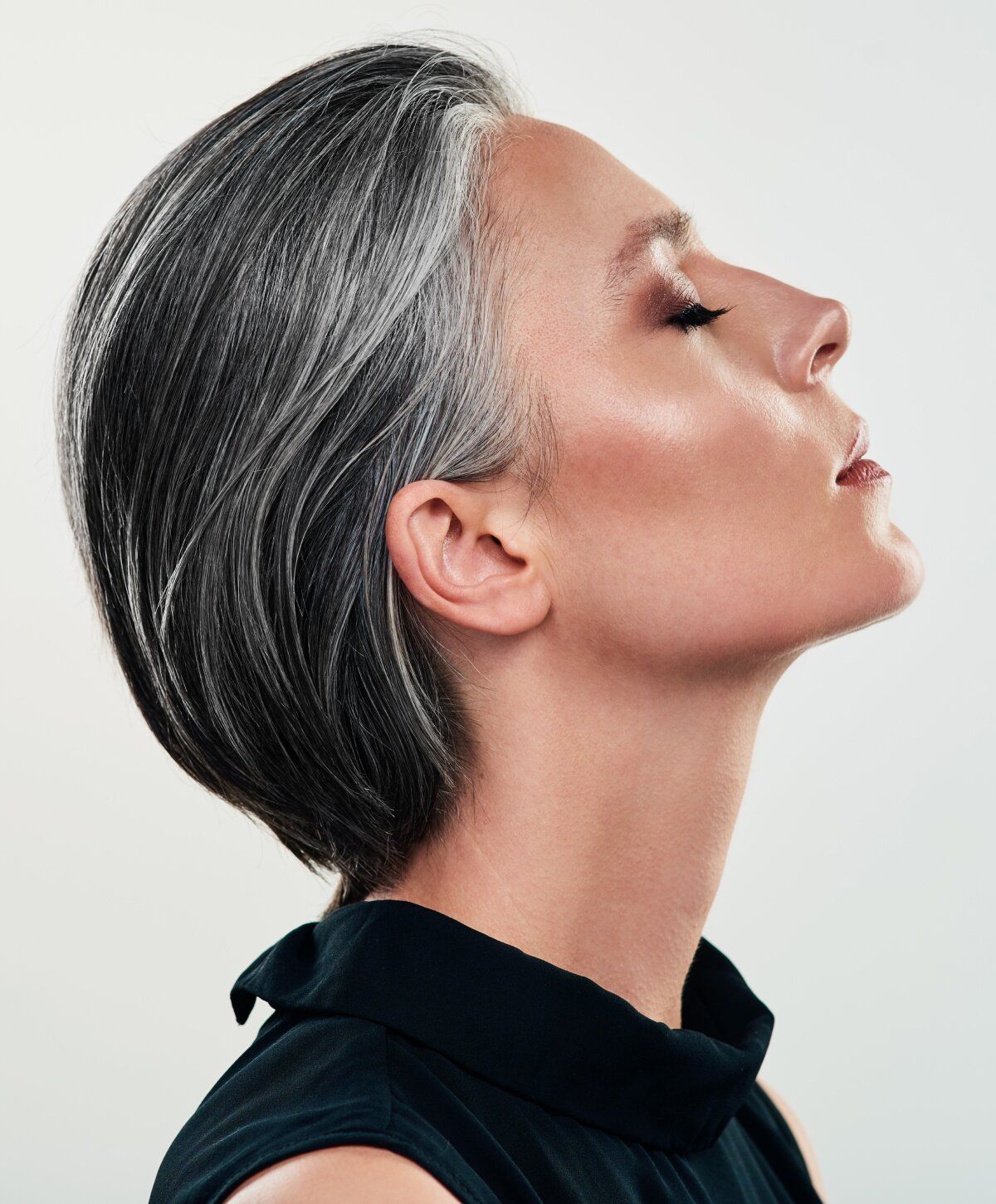 Profile of a rhinoplasty model with sleek gray hair