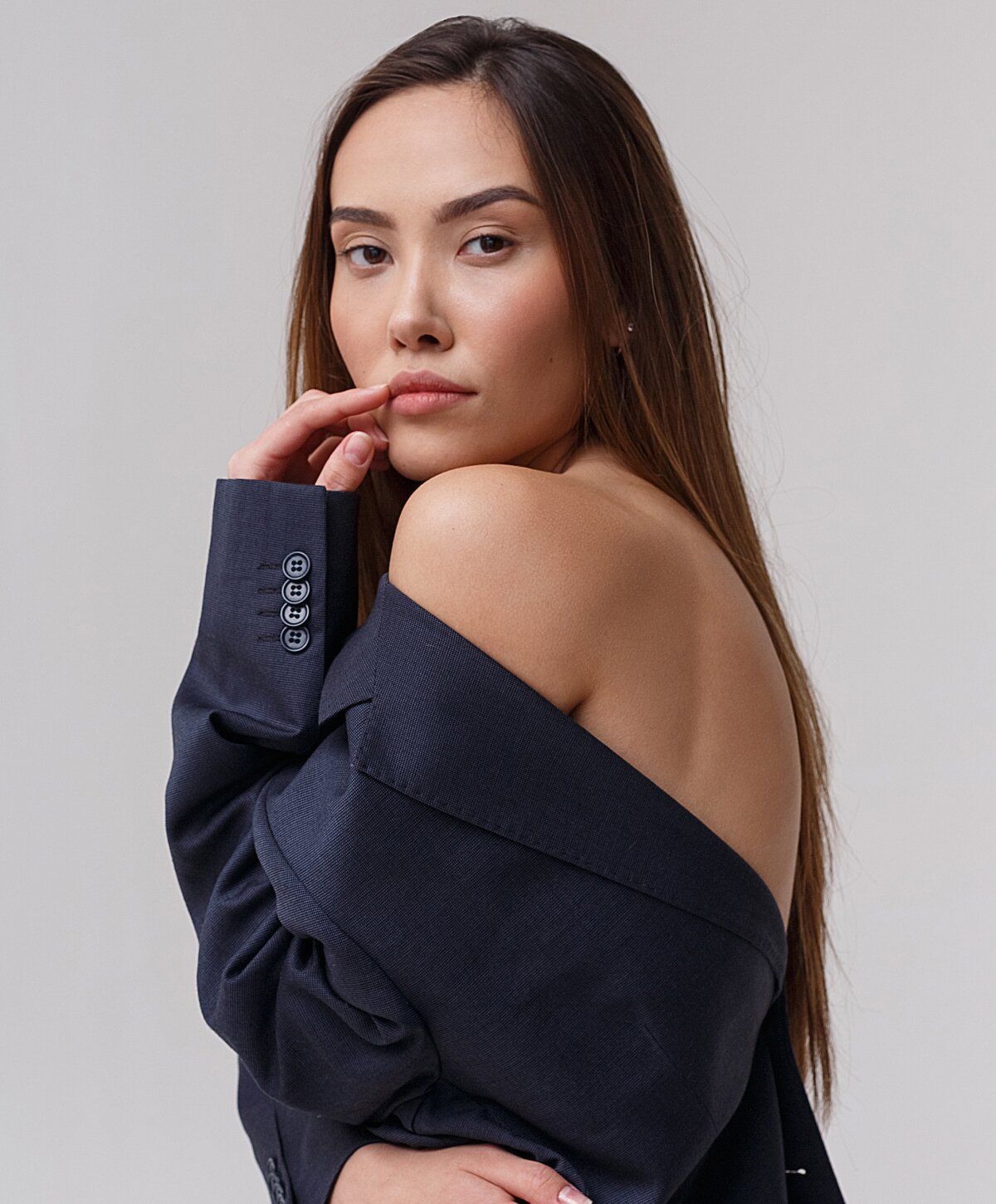 Chemical peel model in oversized blazer, elegant pose.