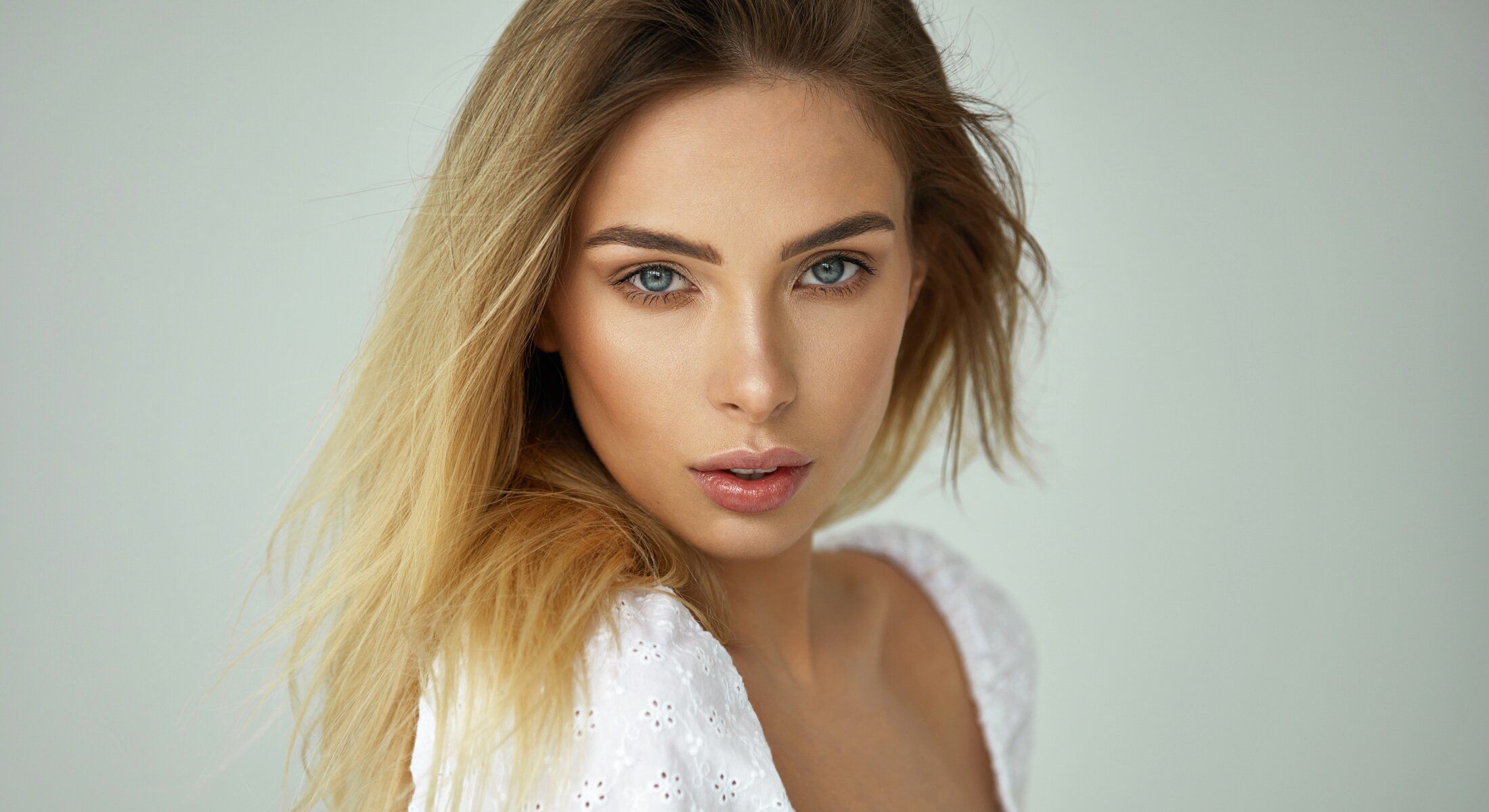Portrait of a lip filler model with long blonde hair.