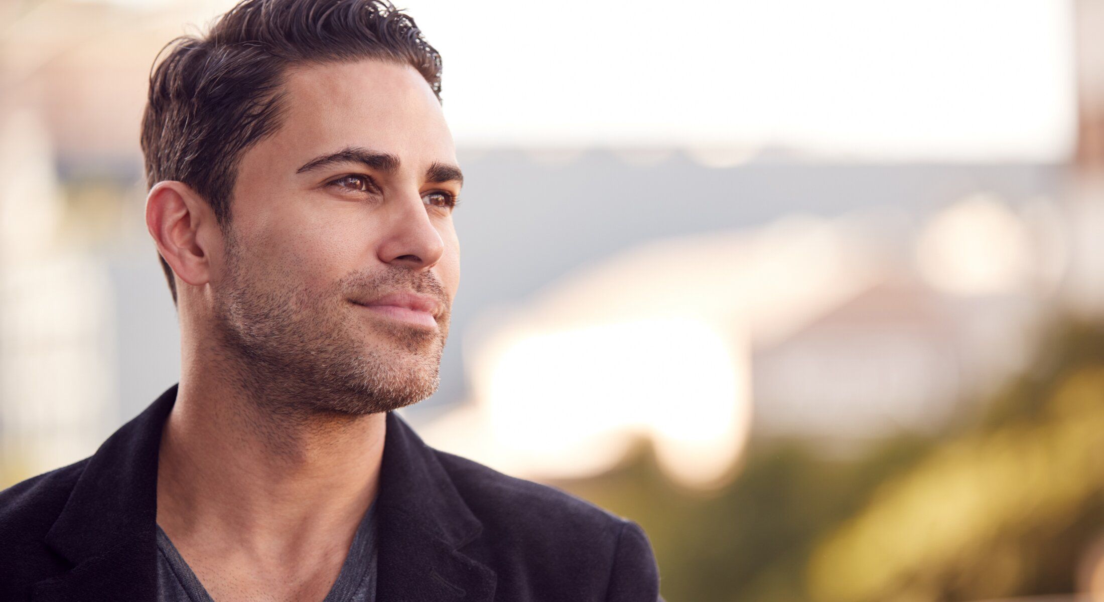 Houston Hair Restoration with PRF model in stylish coat outdoors, looking away upward.