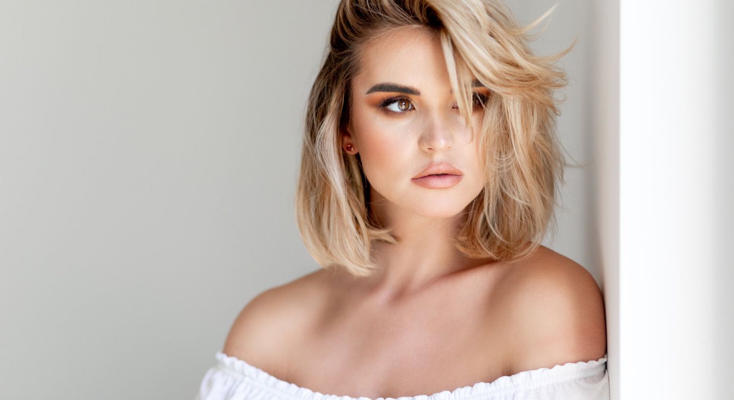 Houston dermal fillers model in a cozy sweater, thoughtful expression.