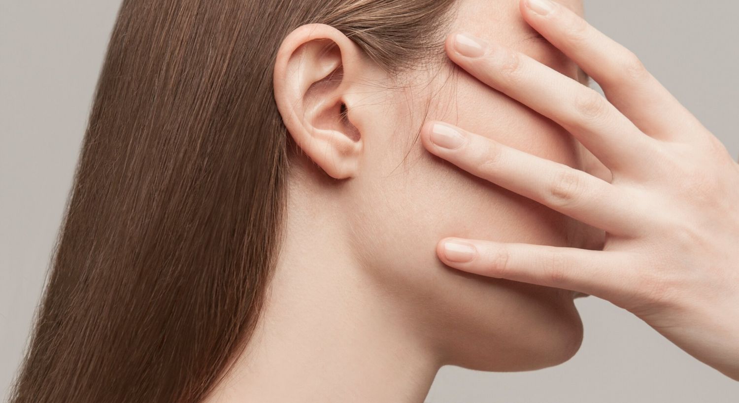 Profile of a woman partially covering her face.
